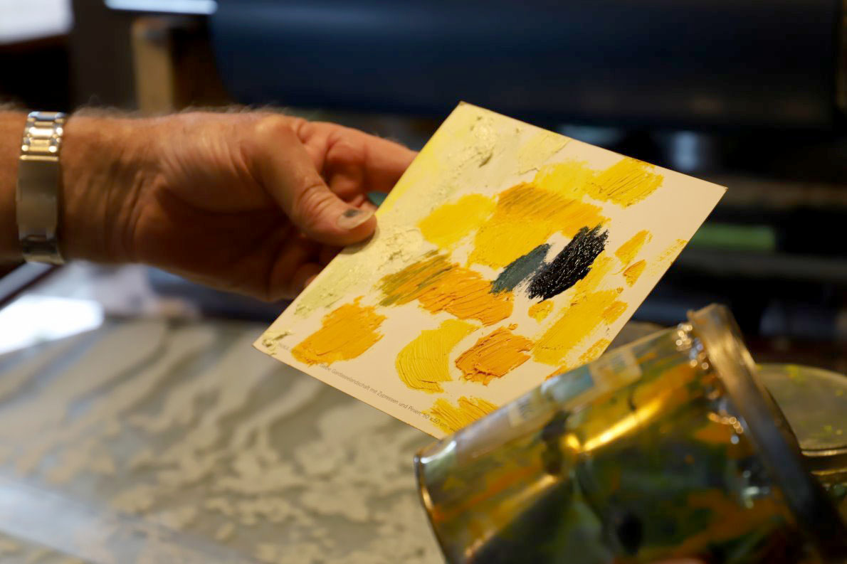 Der Steindrucker hält jetzt eine Palette mit Ölfarben in seiner Hand. Die Grundtöne sind überwiegend gelb. Foto: Knut Kuckel
